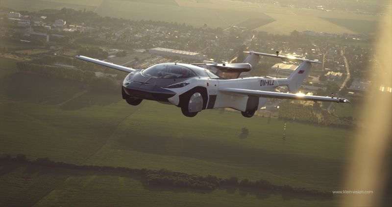 the vehicle looks like a sport car in front but with two wings and a propeller at the back