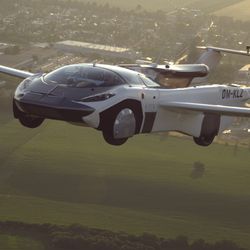 the vehicle looks like a sport car in front but with two wings and a propeller at the back