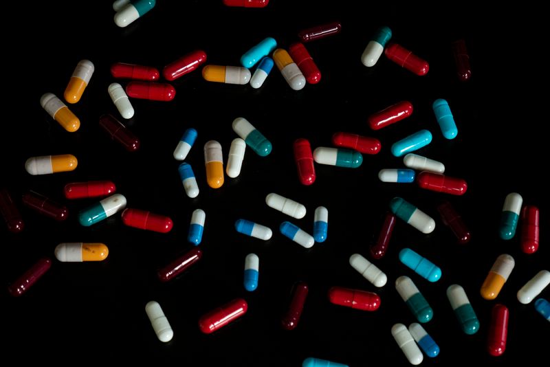 scattered multicolored capsules on a black background