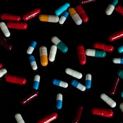 scattered multicolored capsules on a black background