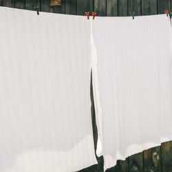 Washed bed sheets on the washing line drying.