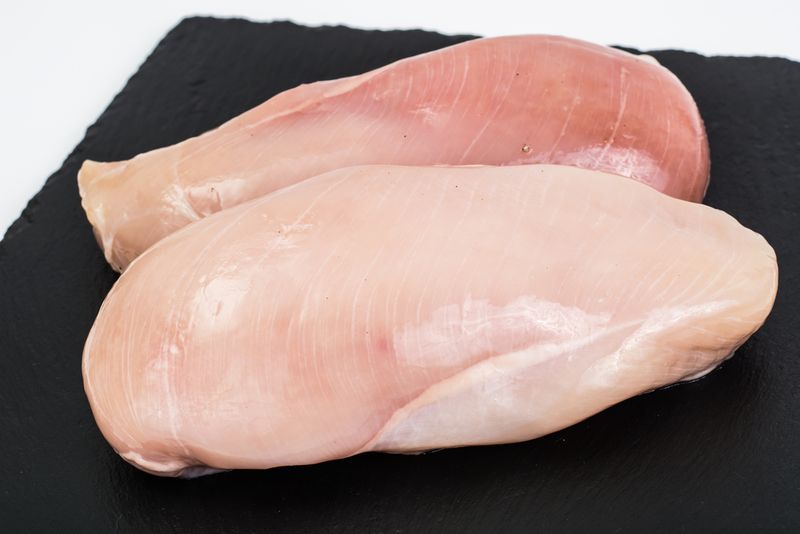 Chicken breast on a board with white stripes on them