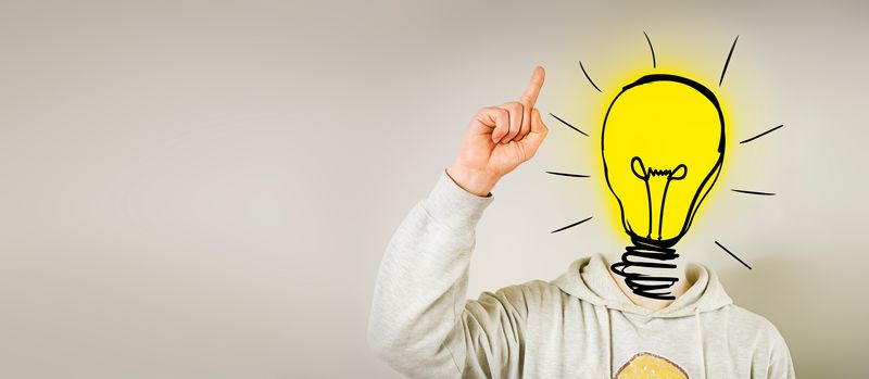 person pointing to the ceiling with their head replaced with a drawing of a yellow lightbulb to represent a flash of inspiration
