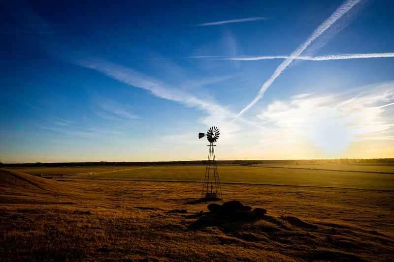 A picturesque field in rural Oklahoma, with sunset in distance