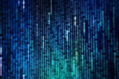strings of vertical binary numbers in shades of blue on a dark background