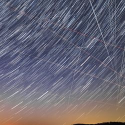 star trail view of the sky with the occasional straight bright line caused by satelites