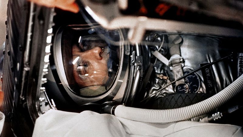 Shepard in his space suit is seen among tubes.
