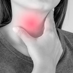 black and white close up of a woman holding her throat, with red overlay to indicate pain