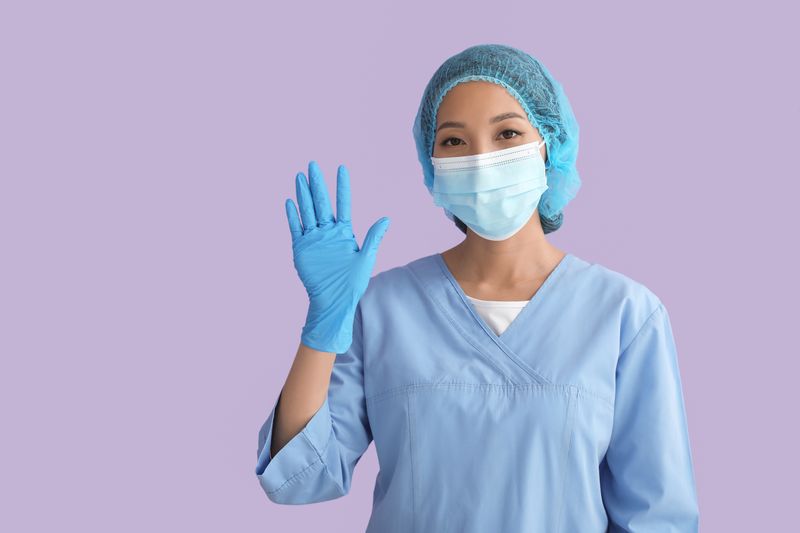 Surgeon wearing scrubs and waving