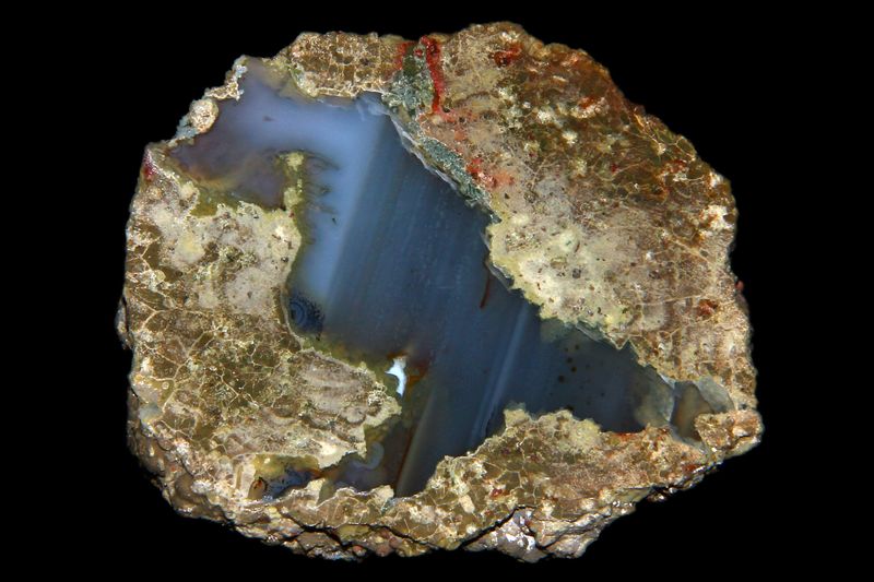 Brown bobbly outer is filled with shiny blue layer that diagonally appears through the rock.