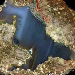 Brown bobbly outer is filled with shiny blue layer that diagonally appears through the rock.