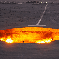 A flaming pit of orange flames at Darvaza Crater in Karakum Desert, Turkmenistan. 