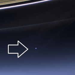 Giant arrow pointing to Earth,  seen as a blue dot underneath the rings of Saturn.  