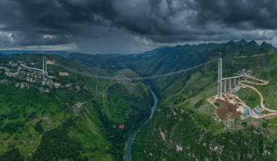 The Huajiang Grand Canyon Bridge (pictured here under construction) is part of an expressway in Zhenfeng County in the southwest of Guizhou province, China. 
