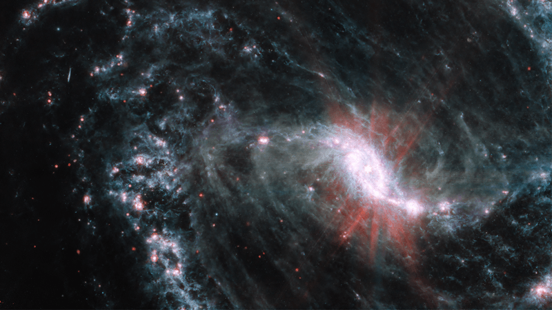a spiral galaxy seen by jwst. the wispy gas present in the arms of the spiral is clearly seen in this image