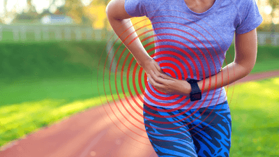close up photograph of a woman in workout clothing slightly bent over in pain, holding her hand on the side of her abdomen