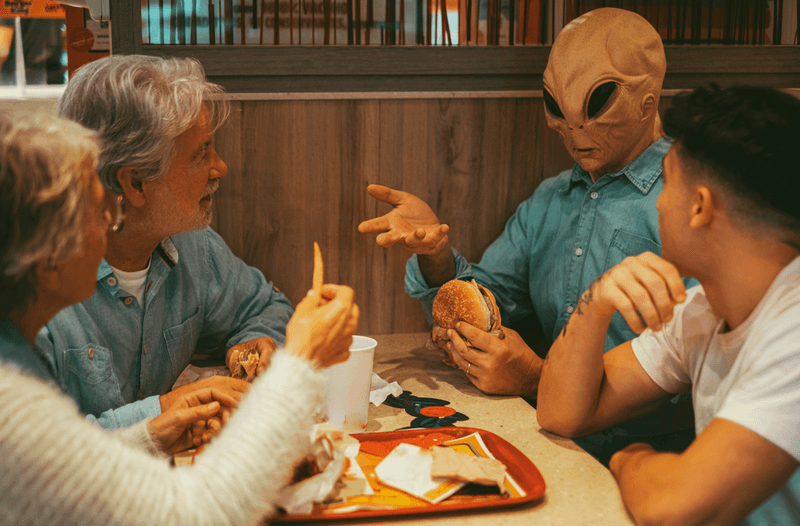 A family talking and having conservation with an alien in a shirt