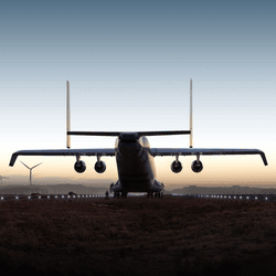A rendering of the Windrunner aircraft driving into the sunset with windturbines.